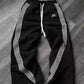 Black women's track pants with white side stripes and drawstring waist, casual fashion wear