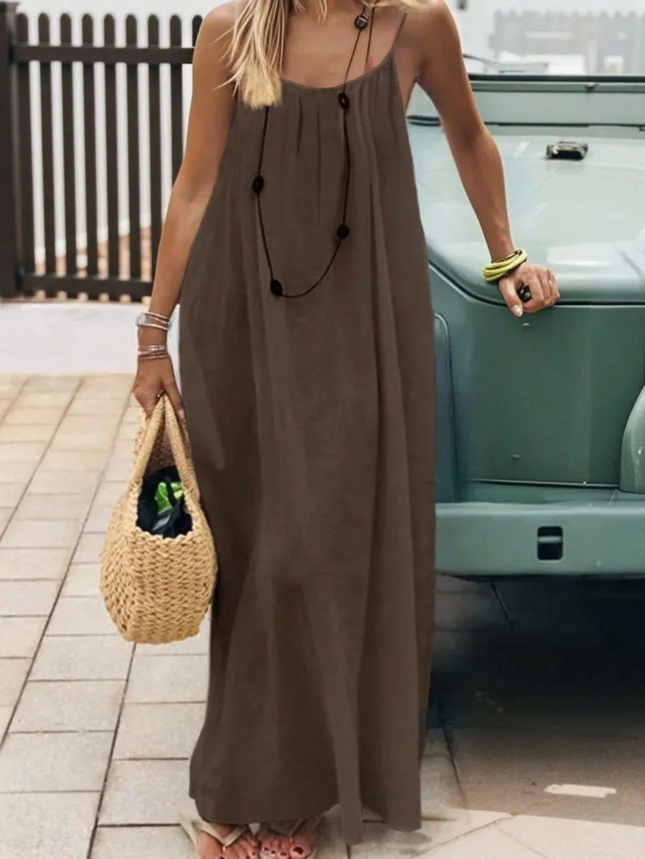 Woman in olive maxi dress with straw bag, boho summer fashion outfit