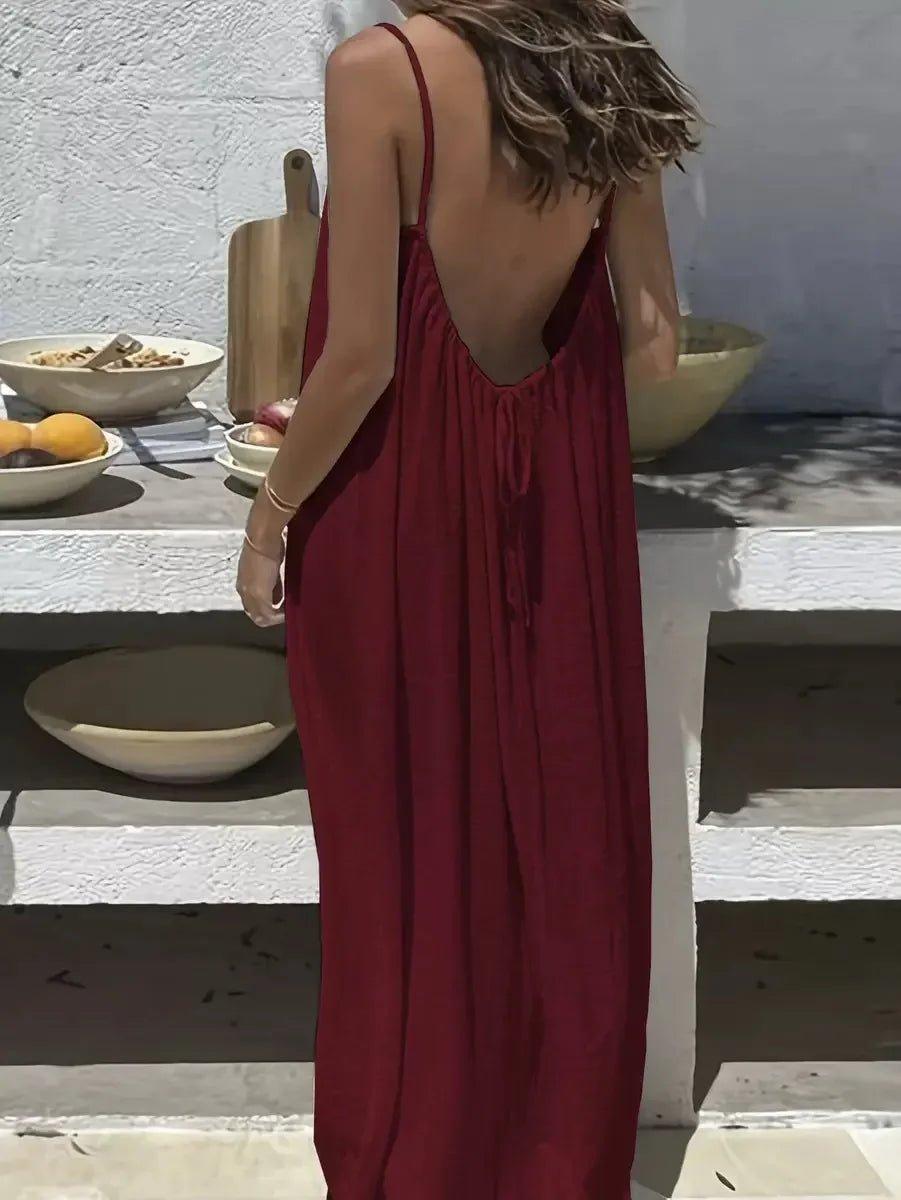 Woman in red backless maxi dress, summer fashion, beach style, boho chic, outdoor dining