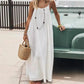 Woman in white maxi dress with straw bag and layered necklace