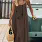 Woman in brown sleeveless maxi dress with straw bag, summer fashion outfit