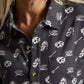 Woman wearing dark button-up shirt with skull and cereal bowl print, fashion top
