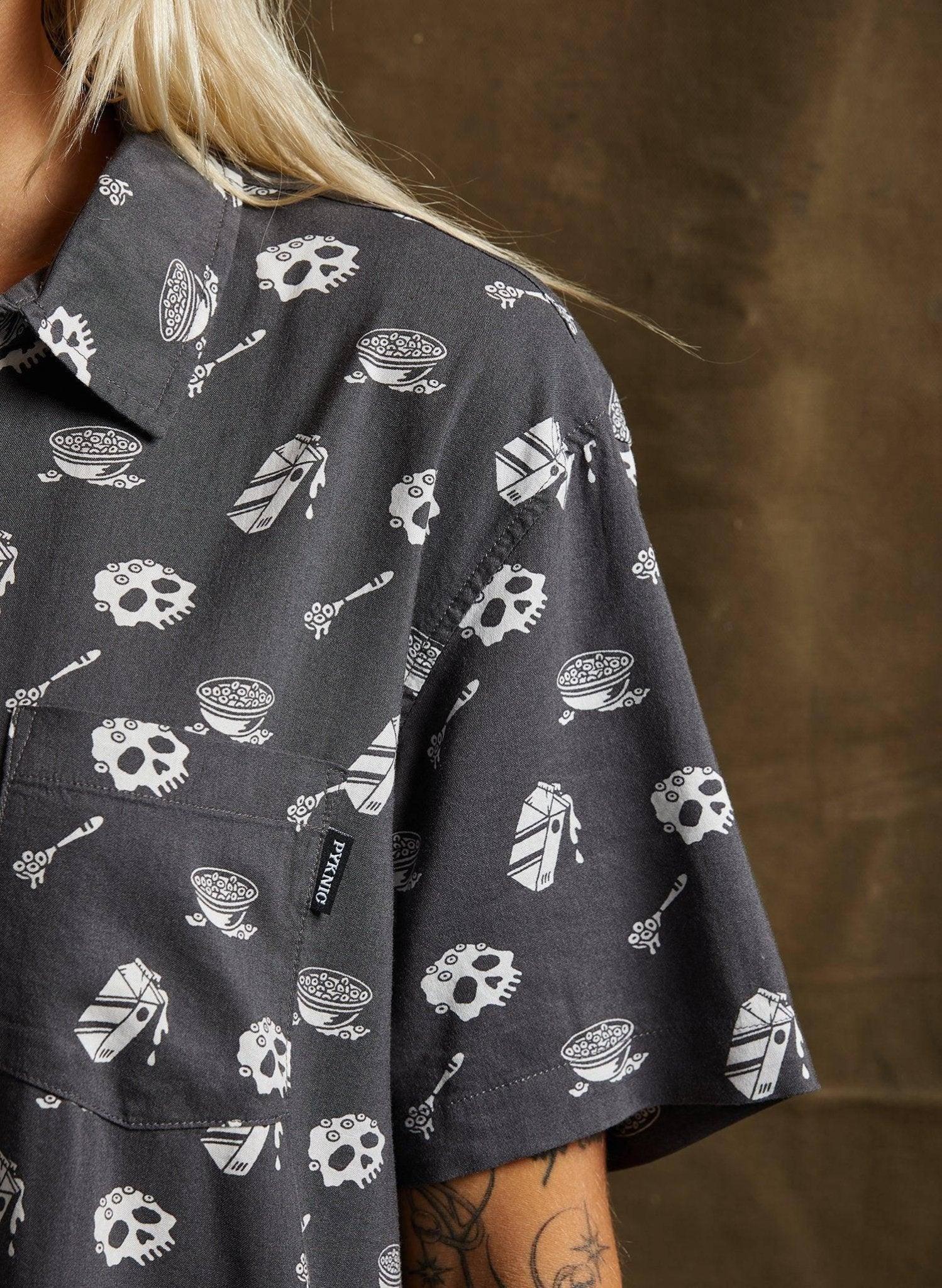 Woman wearing dark gray short sleeve shirt with skull, cereal bowl, and milk carton print, fashion style