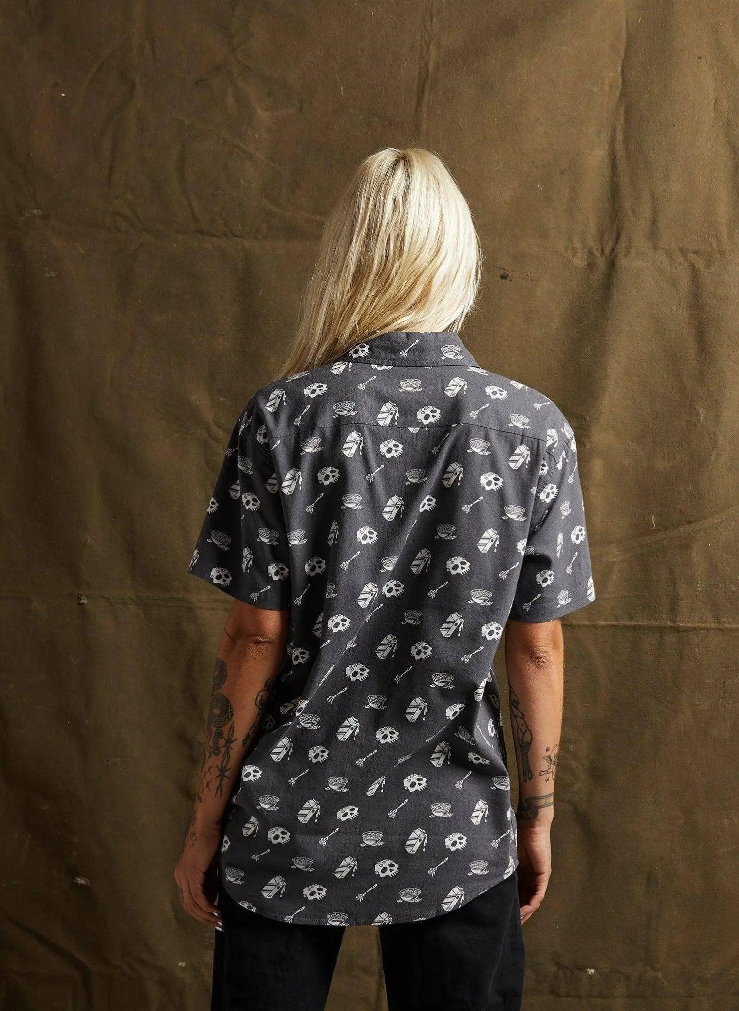 Woman wearing dark short-sleeve shirt with white skull and bone print, back view, fashion style