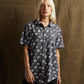 Woman wearing edgy skull print short sleeve button up shirt, fashion top for women