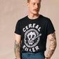 Man wearing black 'Cereal Killer' graphic tee with tattoos, styled for men's fashion