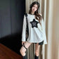 Woman in white star-print top, black shorts, thigh strap, and headphones — trendy fashion outfit
