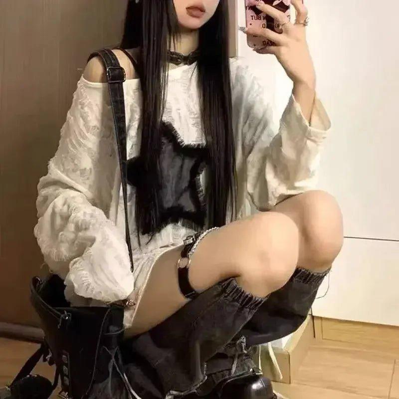 Woman in white lace top, black choker, and knee-high boots taking mirror selfie