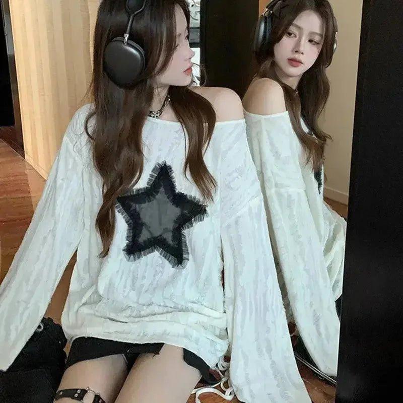 Woman in white off-shoulder top with black star print, wearing headphones, fashion style