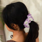 Purple and white knitted scrunchie in woman's ponytail, fashion hair accessory