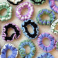 Colorful crocheted hair scrunchies in pastel and bold patterns, perfect for women's fashion accessories