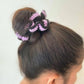 Purple and black knitted scrunchie in a sleek bun, stylish women's hair accessory for fashion looks