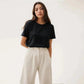 Woman wearing black short sleeve top and cream wide leg pants, stylish casual fashion outfit