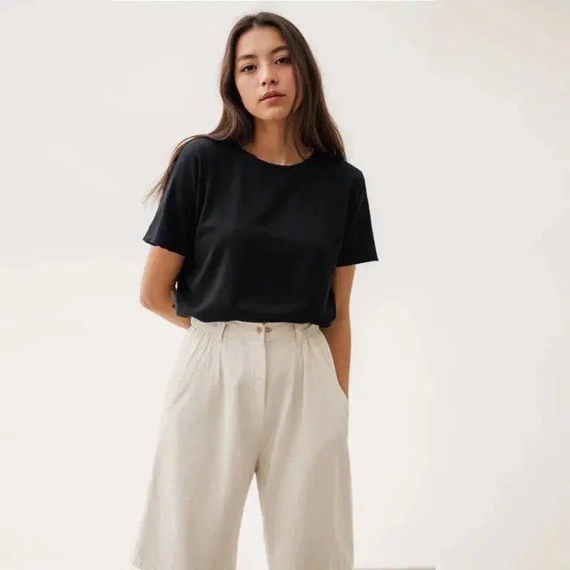 Woman wearing black short sleeve top and cream wide leg pants, stylish casual fashion outfit