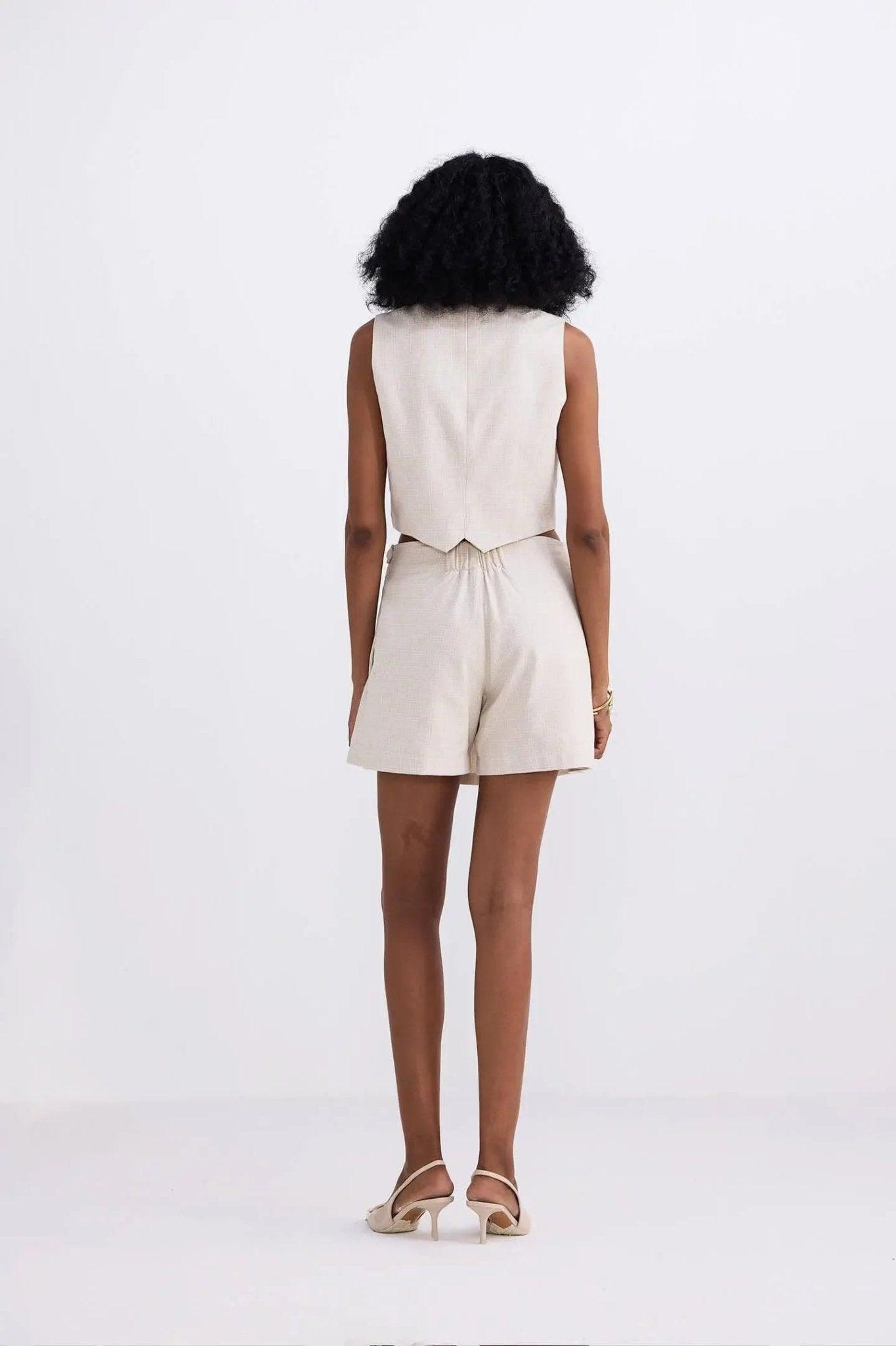 Woman in beige sleeveless top and matching shorts, back view, stylish summer fashion set