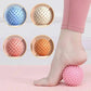 Pink spiky foot massage ball for plantar fasciitis relief, shown with foot on mat, 4 color options