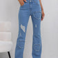 Women's high-waist distressed jeans with heart-shaped rips, flared legs, and frayed hems for trendy fashion