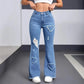 Women's high-waisted flare jeans with heart-shaped rips, paired with white crop top and sneakers