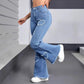 Women's high-waisted ripped flare jeans with heart cutouts, paired with white sneakers for casual fashion