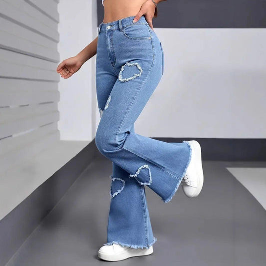 Women's distressed flare jeans with heart-shaped rips, paired with white sneakers for casual fashion