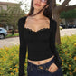 Woman in black long sleeve crop top with lace trim and jeans, outdoor fashion look