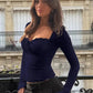 Woman in navy lace-trim top and striped pants on balcony, fashion style