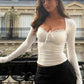 White lace-trim long sleeve top with tie front, paired with black pinstripe pants, chic women's fashion