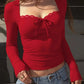 Red long sleeve crop top with lace trim and front bow, paired with denim jeans for women's fashion