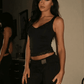 Woman in black lace crop top and high-waist pants, stylish fashion outfit