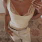 Cream lace-trimmed camisole top with matching pants, styled with delicate necklace and rings for women's fashion