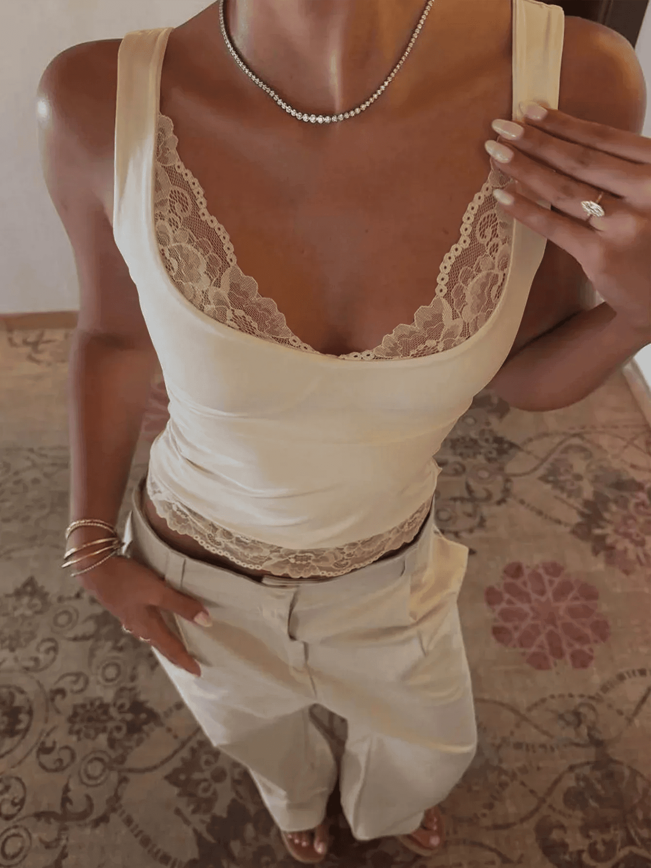 Cream lace-trimmed camisole top with matching pants, styled with delicate necklace and rings for women's fashion