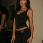 Woman in black lace crop top and high-waist pants, stylish fashion outfit