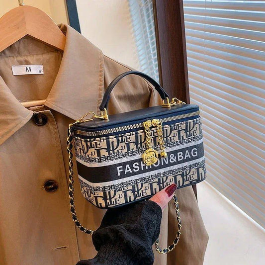 Stylish women's fashion handbag with chain strap and 'FASHION&BAG' print, paired with beige coat