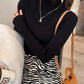 Woman in black ribbed turtleneck and zebra print skirt with gold accessories