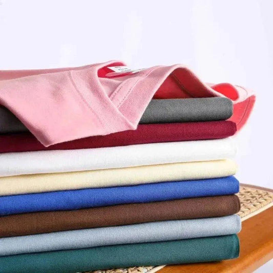 Stack of colorful women's fashion t-shirts in pink, red, white, blue, brown, gray, and green
