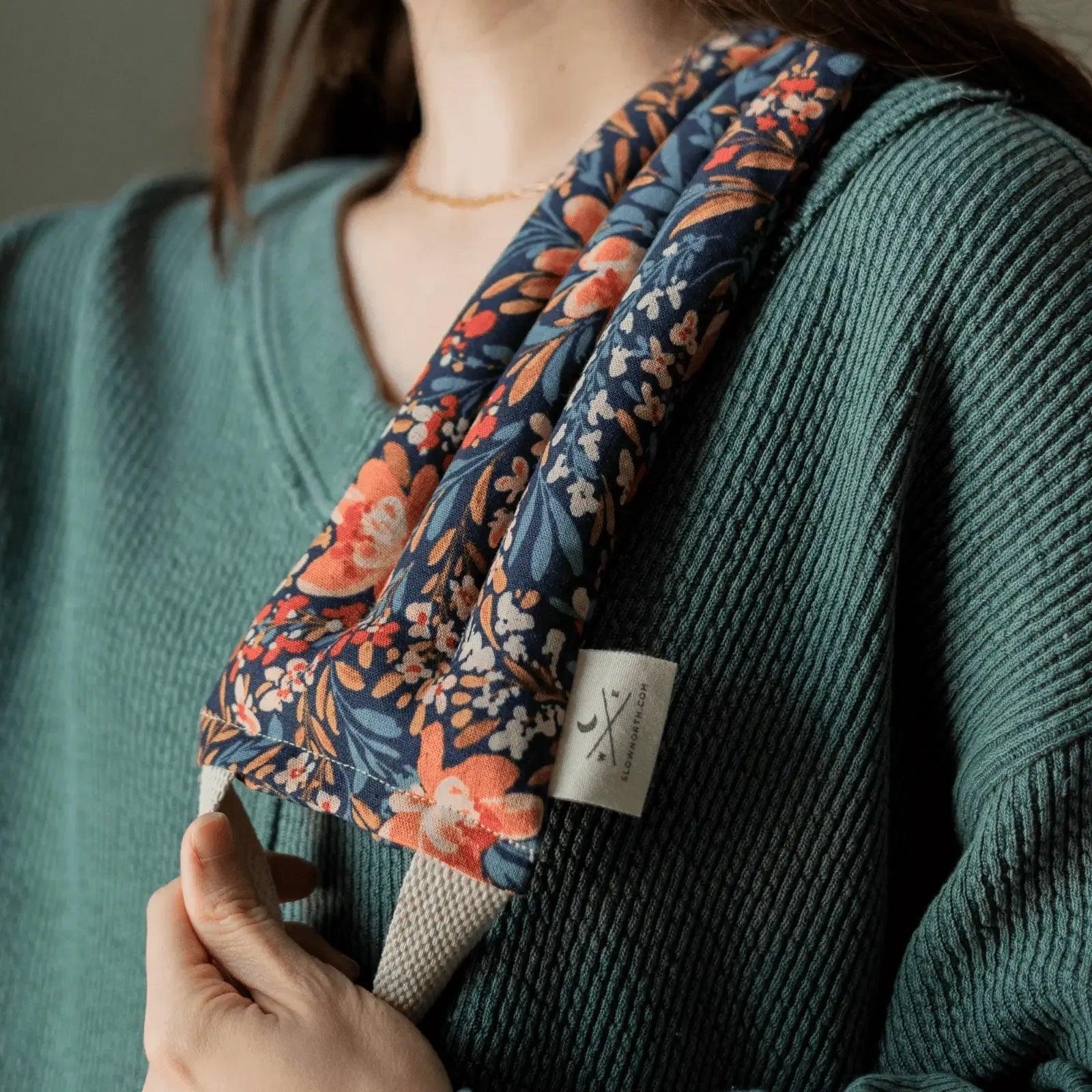 Floral print scarf with orange and blue blooms, styled with teal ribbed sweater for women's fashion