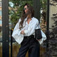 Woman in white blouse and black pants holding coffee cup, stylish streetwear fashion outfit