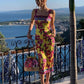 Woman in yellow floral dress with ocean view, summer fashion style