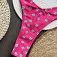 Pink floral bikini bottom with white daisies on woven straw hats, beach fashion