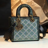 Elegant green snakeskin handbag with crystal quilted pattern, gold hardware, and detachable strap for women's fashion.