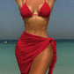 Red bikini top and matching sarong wrap at beach, women's summer fashion
