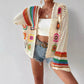 Boho crochet cardigan with colorful floral patterns, worn over white top and denim shorts for summer fashion.