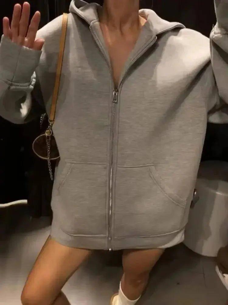 Woman wearing gray zip-up hoodie with front pockets, casual fashion outfit