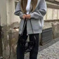 Woman in gray hoodie, black jeans, and studded bag for casual streetwear fashion