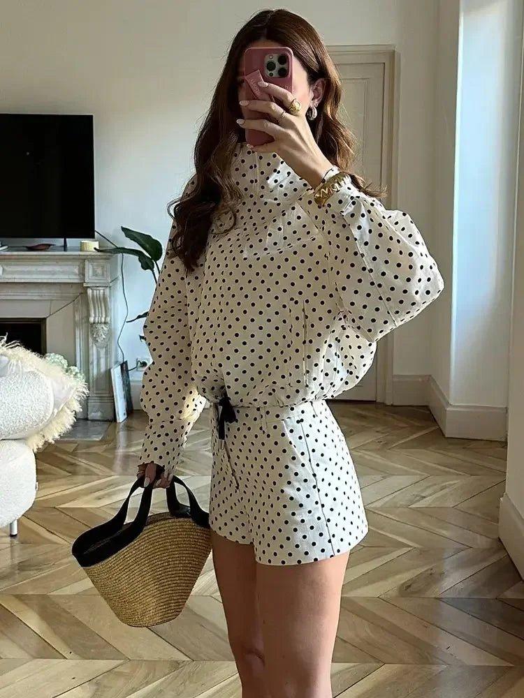 Woman in polka dot blouse and shorts with straw bag, stylish home fashion outfit