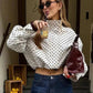 Woman in polka dot crop top, denim shorts, sunglasses, holding drink and burgundy bag