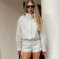 Woman in white polka dot long sleeve top and matching shorts, stylish summer outfit