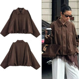 Brown oversized fashion jacket with cape sleeves, styled streetwear for women