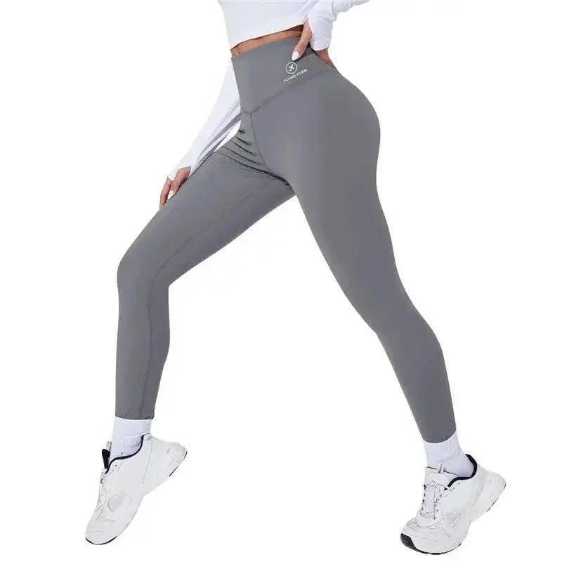 Gray high-waisted workout leggings for women, paired with white sneakers and crop top