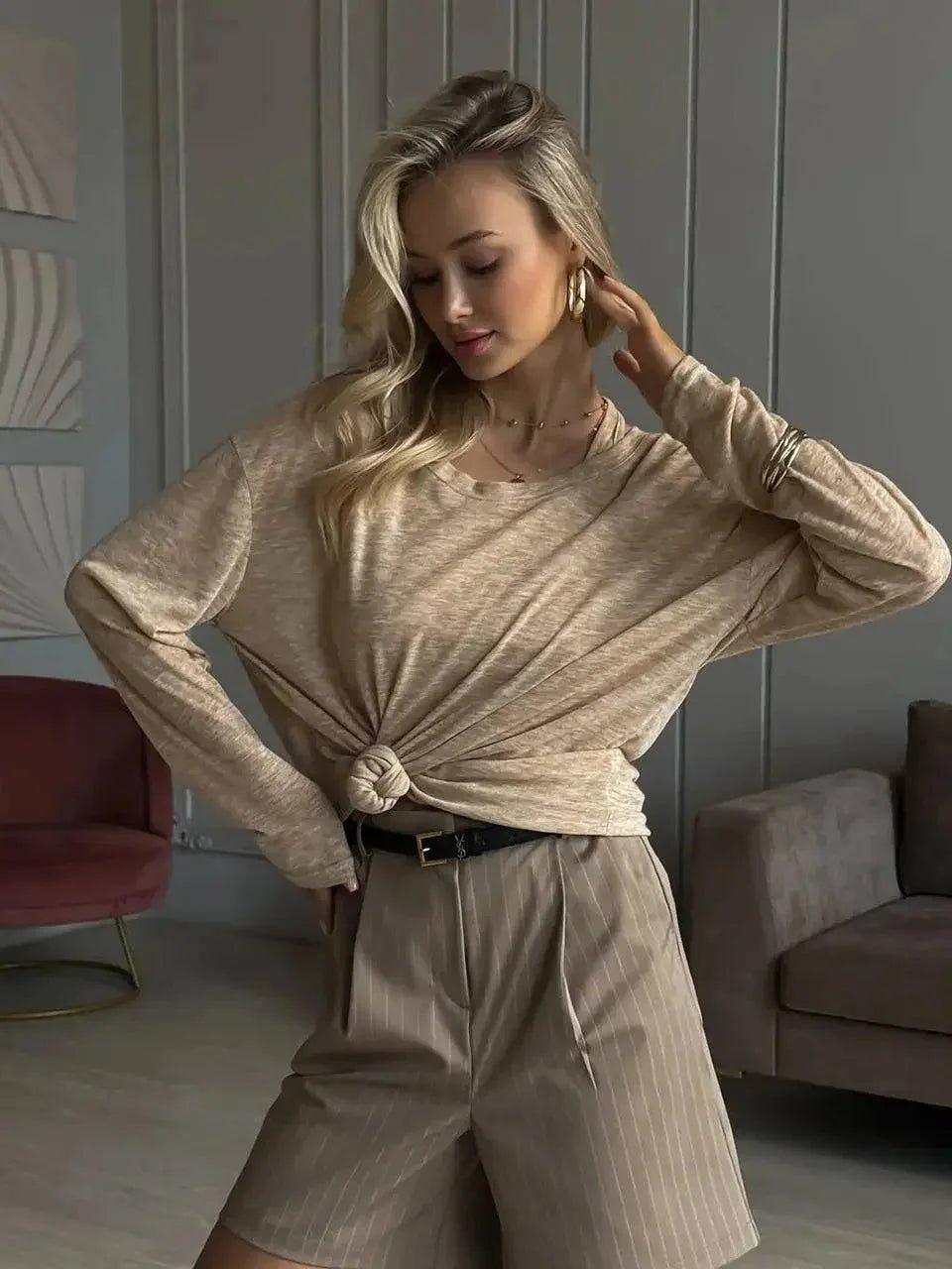 Woman in beige knotted long sleeve top and pinstripe shorts, stylish casual fashion outfit